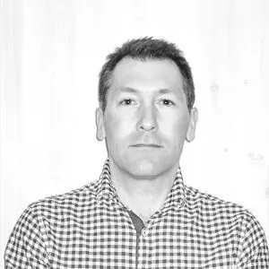 Mann i hvit rutete skjorte foran hvit vegg